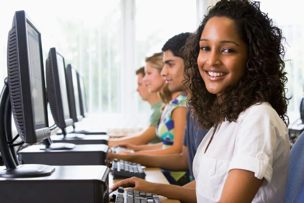 student smiling at the computer promoting an educational assessment platform built for professionals​